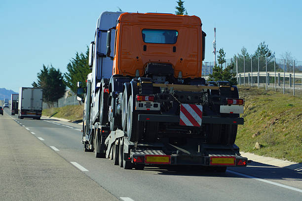 A truck transporting trucks on a highway in Spain.